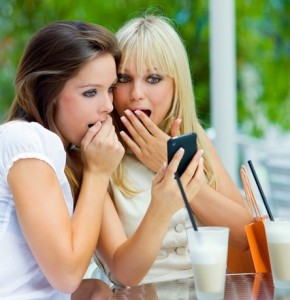 Zwei junge Frauen im Cafe beim telefonieren